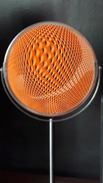 A close-up of a high-quality microphone with a pop filter in a professional recording studio.