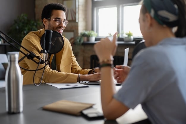 A person smiling while being interviewed on a podcast, sitting across from the host in a cozy studio setting. The atmosphere is relaxed and conversational, emphasizing the personal connection of podcast interviews.