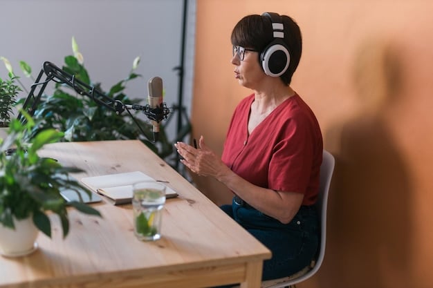 A person wearing headphones, speaking confidently into a professional podcast microphone, with a laptop displaying a video call interface. The scene suggests an engaging remote podcast interview.