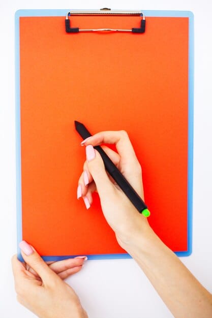 A person's hand holding a pen, highlighting key information on a printed document with a 